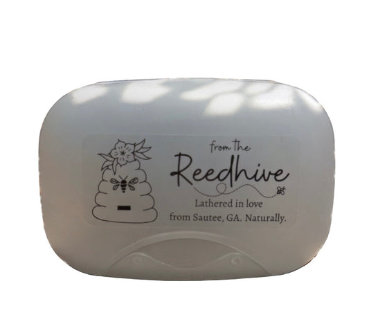 white soap case with 'from the Reedhive' sticker on a natural background
