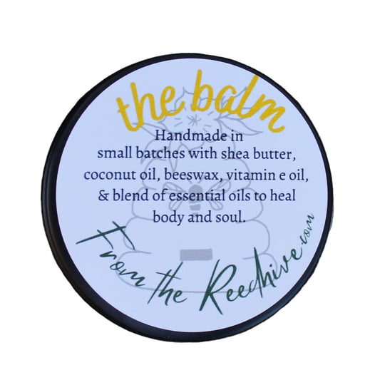 Round label on a tree trunk with text about 'The Balm' product.