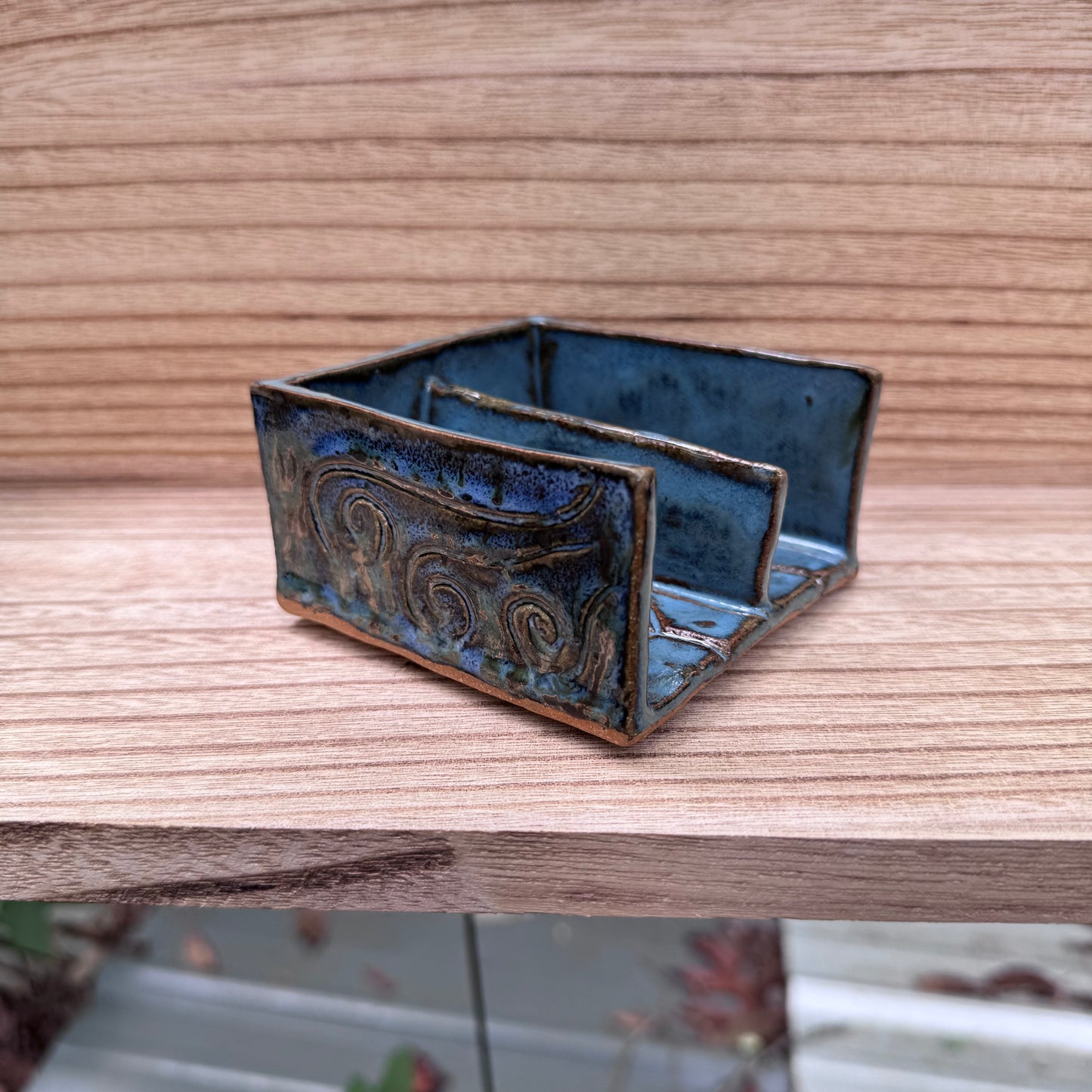 Blue ceramic soap dish with decorative patterns on a wooden surface