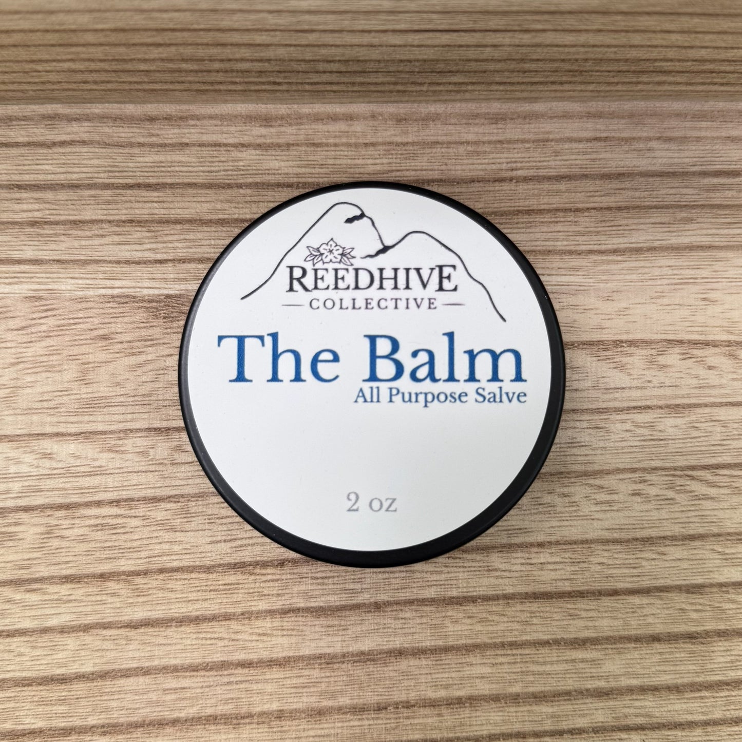 Container of 'The Balm' by Reedhive Collective on a wooden surface