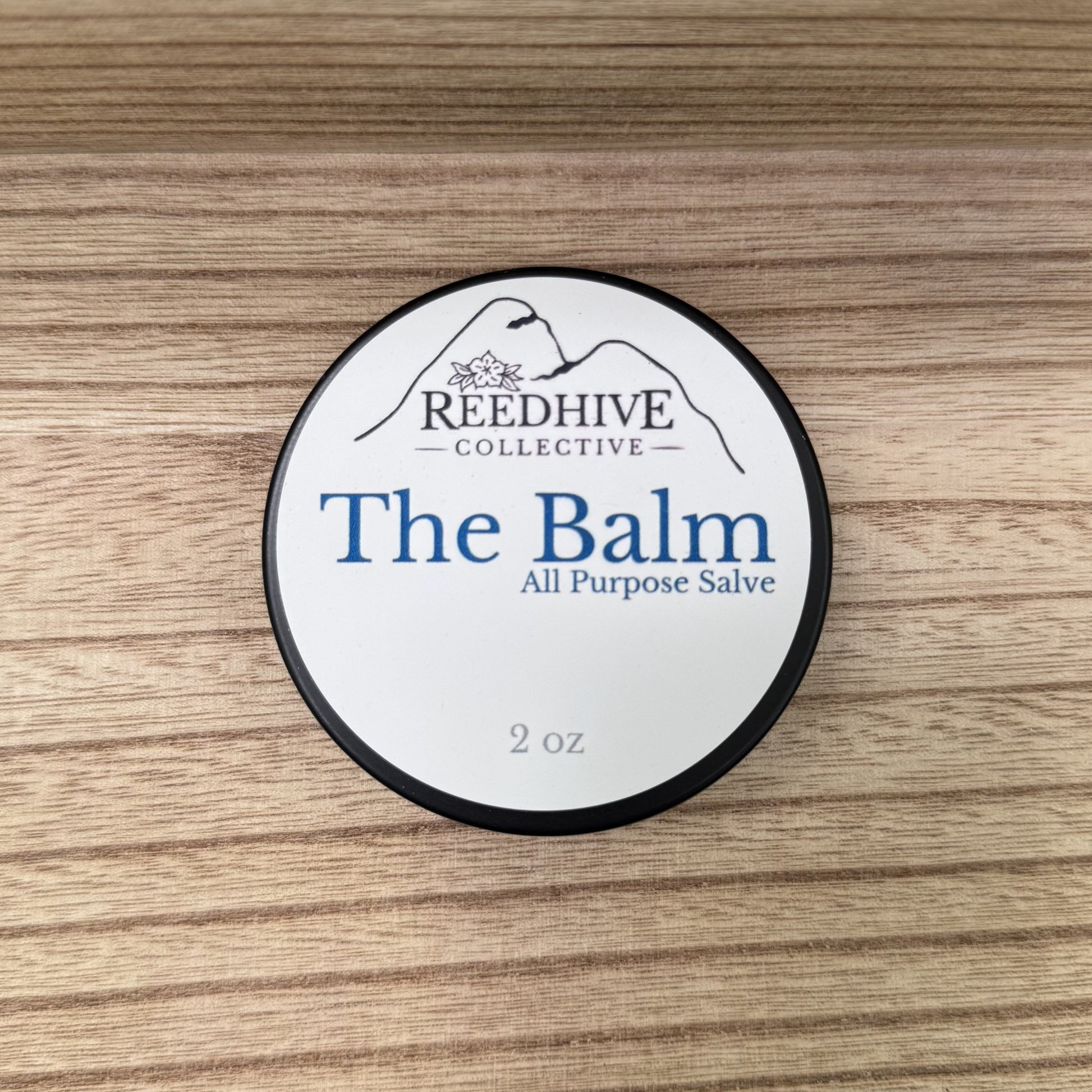 Container of 'The Balm' by Reedhive Collective on a wooden surface